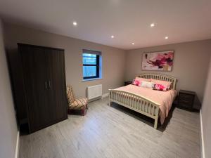 a bedroom with a bed and a chair and a window at seaview 87 in Portrush
