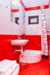 bagno rosso con lavandino e servizi igienici di Apartments Mikulić a Rogoznica (Rogosnizza)