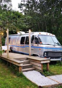 a silver and blue van parked next to a wooden ramp at Glamping 1970 American Airstream motorhome in Ponsanooth
