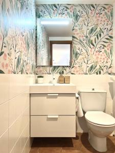 baño con aseo y papel pintado con motivos florales en Elena Playa Sol, en Alcudia