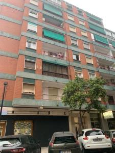 een hoog gebouw met auto's geparkeerd voor het bij Habitación individual in Valencia