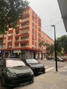 twee auto's geparkeerd op een straat voor een gebouw bij Habitación individual in Valencia