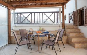 a dining room with a table and chairs and stairs at Kouremenos Beach House West in Sitia