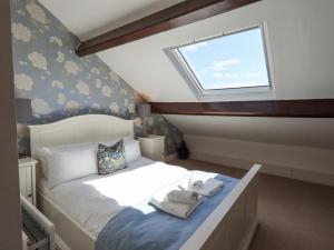 a bedroom with a bed with towels on it at Stablemans Cottage at Stepping Stones in Ambleside