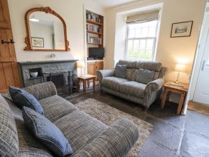 a living room with a couch and a fireplace at Slaters Rest in Chapel Stile