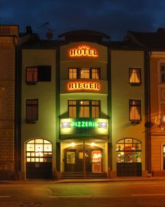 un hotel con un letrero de neón delante de él en Hotel Rieger Garni, en Jičín