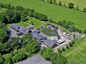 eine Luftansicht eines Hauses mit einem Teich auf einem Feld in der Unterkunft IQBAL-Hütte FeWo Appartement - Ankerplatz in Beverstedt