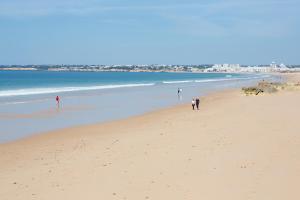 a group of people walking on the beach at Bayside Salgados in Albufeira