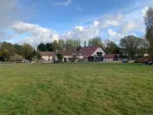 um grande campo de relva com uma casa ao fundo em A stunning converted barn offering country life. em Chewton Mendip