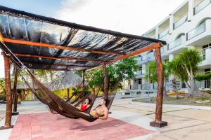 a man and a woman sitting in a hammock at Uxmal Resort Maya in Uxmal
