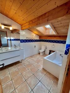 La salle de bains est pourvue d'une baignoire, d'un lavabo et de toilettes. dans l'établissement Résidences Delavay Les Pistes, aux Gets