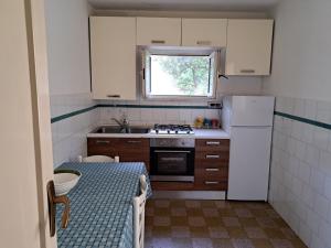 una pequeña cocina con mesa y nevera en La casa Dei Dadi en Milazzo