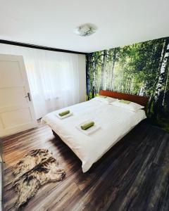 1 dormitorio con 1 cama grande y un mural de bosque en la pared en Green apartment Sarajevo, en Sarajevo