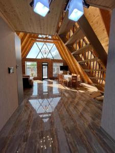 a large room with wooden ceilings and a dining room at Qafqaz house in Gabala