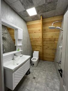 ein Badezimmer mit einem weißen Waschbecken und einem WC in der Unterkunft Qafqaz house in Qəbələ