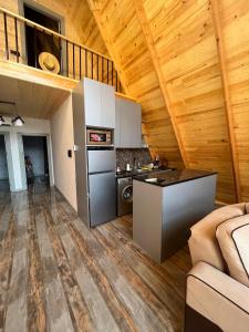 eine Küche und ein Wohnzimmer in einem Blockhaus in der Unterkunft Qafqaz house in Qəbələ