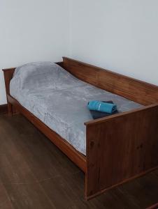 un letto con struttura in legno e cuscino blu di LS Alojamientos Posadas Misiones a Posadas