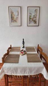 una mesa con dos sillas y un mantel blanco. en Gazdinstvo Kraljevic, en Kraljevići