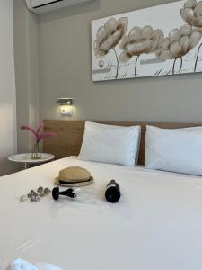 a white bed with a hat and glasses on it at House Kohili in Nea Vrasna
