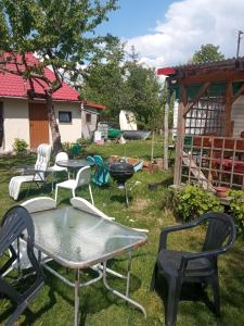un grupo de sillas y mesas en un patio en Domek letni, en Pozezdrze