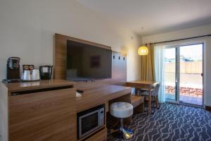 a living room with a flat screen tv and a desk at Dreamcatcher Inn of Sedona in Sedona