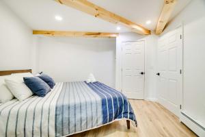 1 dormitorio con 1 cama con manta de rayas azul y blanco en Scenic Pocono Pines Apartment with Fire Pit!, en Pocono Pines