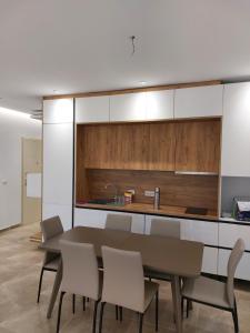 a kitchen and dining room with a table and chairs at Illyrian Elite Gjiri i Lalezit in Durrës