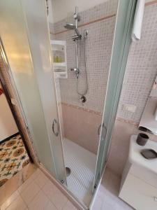 La salle de bains est pourvue d'une douche avec une porte en verre. dans l'établissement A casa di Nonna Giò, à Palerme