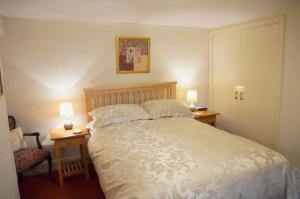 ein Schlafzimmer mit einem großen Bett mit zwei Tischen und zwei Lampen in der Unterkunft Keepers in Alston