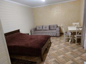 a room with a bed and a table and a couch at Котедж у Ліску 2 in Vorokhta