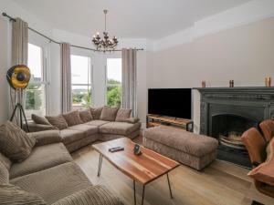 a living room with a couch and a fireplace at The Priory in Torquay