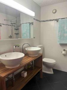 a bathroom with two sinks and a toilet at Appartement Haute-Nendaz in Nendaz