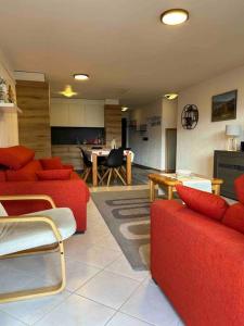 a living room with red furniture and a kitchen at Appartement Haute-Nendaz in Nendaz