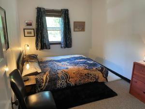 een slaapkamer met een bed, een stoel en een raam bij Come and Get your Love at Hikers Haven! Only 10 minutes from Mount Shasta-Pet Friendly in Mount Shasta