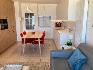 cocina y comedor con mesa y sillas en Apartment "Zeezicht", en Ostende