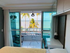 a bedroom with a bed and a view of the ocean at Blue Sunset Prime com vista para mar in João Pessoa