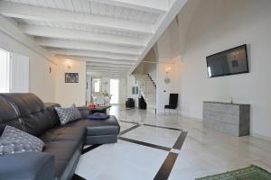 ein Wohnzimmer mit einer Couch und einem Fernseher an der Wand in der Unterkunft Salentuosi - Salento Mille e una Notte in Racale + 75 Fotos