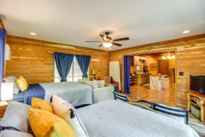 a bedroom with two beds and a living room at Rural Arkansas Vacation Rental with Wraparound Porch in Heber Springs