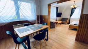 Una habitación con una mesa y sillas y un dormitorio. en Apartamenty w Maniowach, en Maniowy