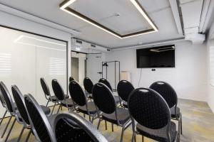 une salle de conférence avec des chaises et un écran de projection dans l'établissement Inger Hotell, à Narva