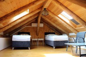 two beds in a room with wooden ceilings at Natúr Komfort Apartmanok in Badacsonytördemic