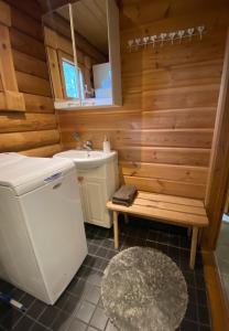 ein Badezimmer mit Waschbecken, Toilette und Sitzbank in der Unterkunft Latvahonka Cottage in Jämsä