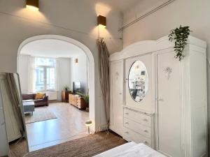 a bedroom with a white cabinet and a living room at Große Loft-Apartments im Herzen Bremens in Bremen