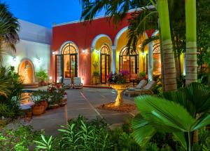 Casa Oasis Guest House and Spa في ميريدا: منزل به ساحة مع أشجار النخيل