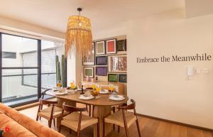 een eetkamer met een tafel en een bank bij Casa Colima by Kukun in Mexico-Stad