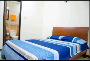 Schlafzimmer mit einem Bett mit blauer und weißer Bettwäsche in der Unterkunft Apartamento Granada 2 habitaciones - 201 in Cali