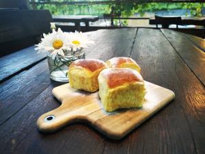 a wooden cutting board with three pieces of bread on a table at Turistična kmetija HLEBEC in Kog