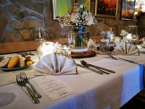 une table avec un tissu de table blanc sur une table avec des fleurs dans l'établissement Turistična kmetija HLEBEC, à Kog