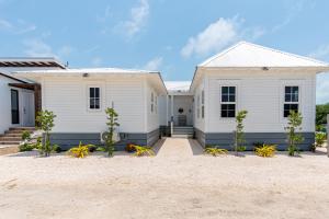 ein weißes Haus mit Pflanzen davor in der Unterkunft Casa de Luz and The PoolClub at Mahogany Bay! in San Pedro
