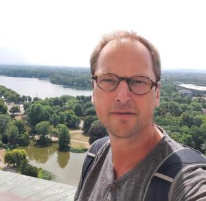 a man wearing glasses standing in front of a river at deinFerienhaus Scheliga „Midi“ in Bad Sobernheim